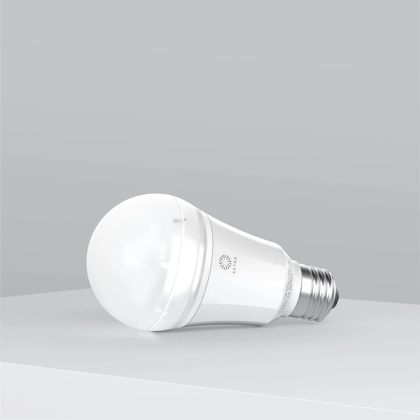 White LED light bulb lying on its side on a gray surface and background