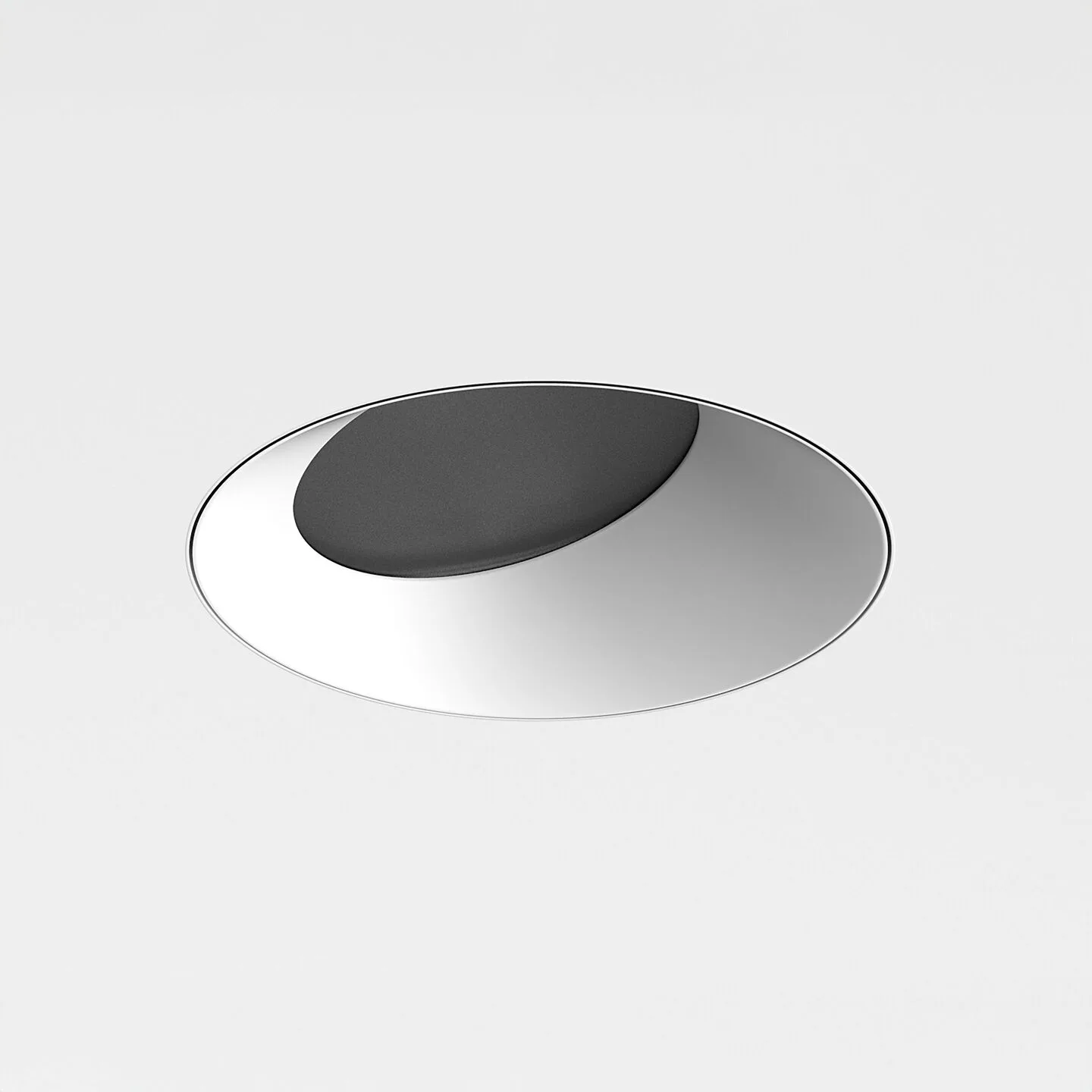 Abstract metallic circular knob: silver disk with a raised dark center, viewed at an angle against a light gray background.