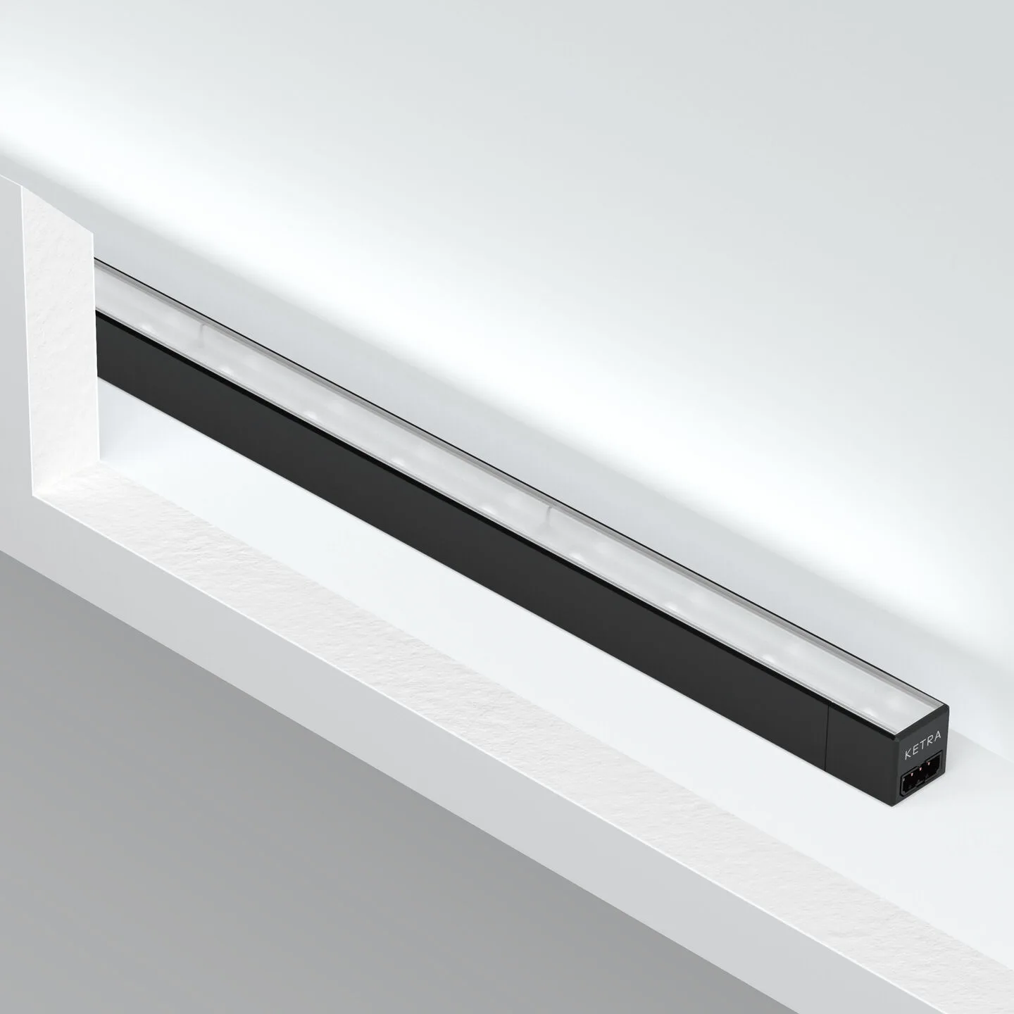 Linear black LED light bar mounted along a white shelf, providing under-shelf illumination (brand: Ketra).