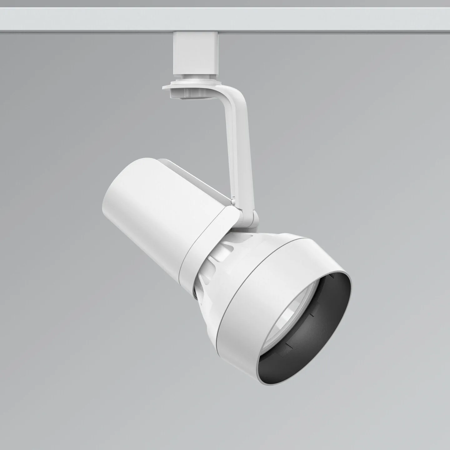 Adjustable white track lighting spotlight mounted to a ceiling track, angled downward to illuminate a space.