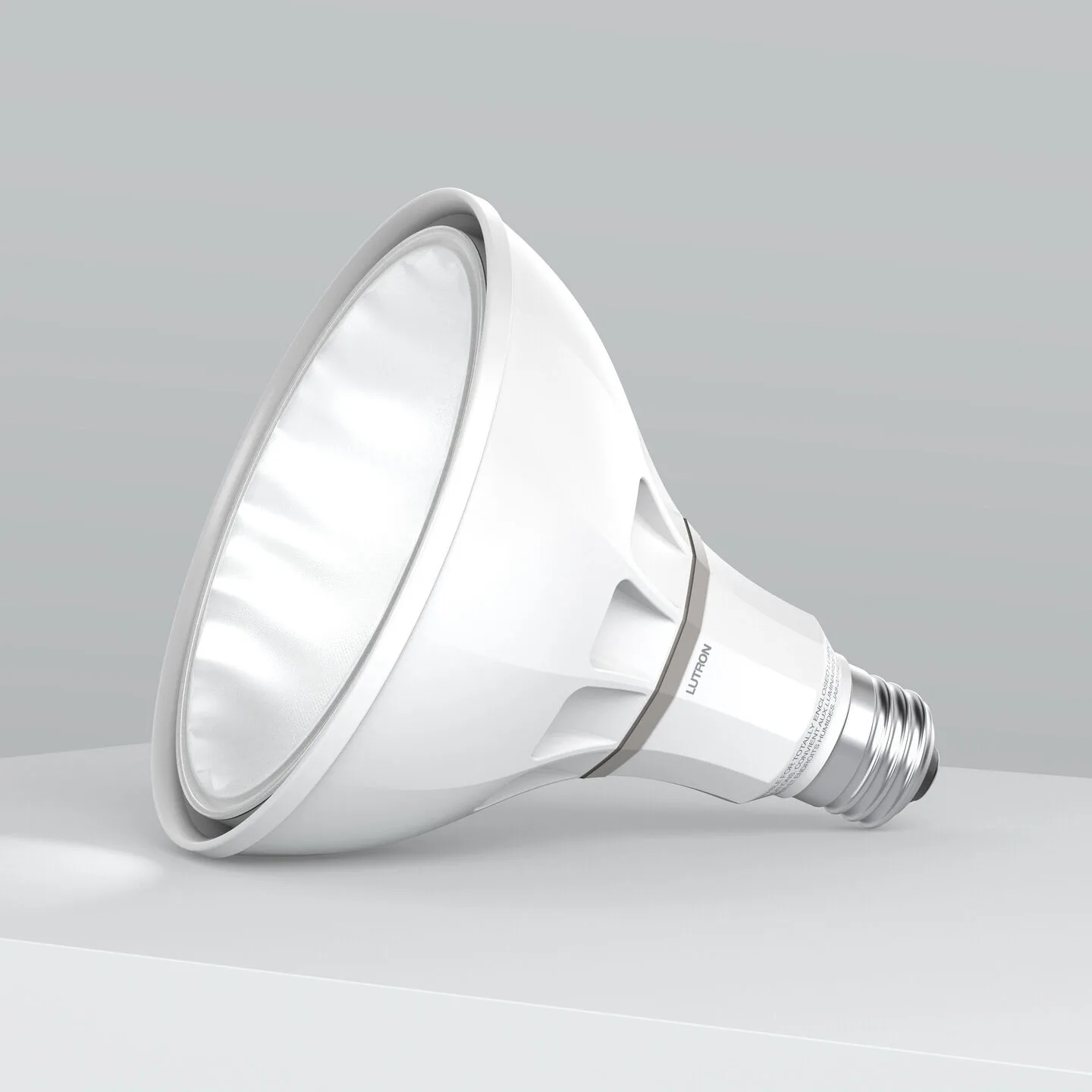 White LED floodlight bulb lying on its side on a gray surface.