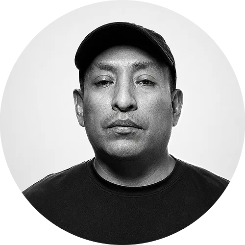 GEORGE Portrait of a man wearing a black cap and T-shirt, facing the camera with a neutral expression (black and white).
