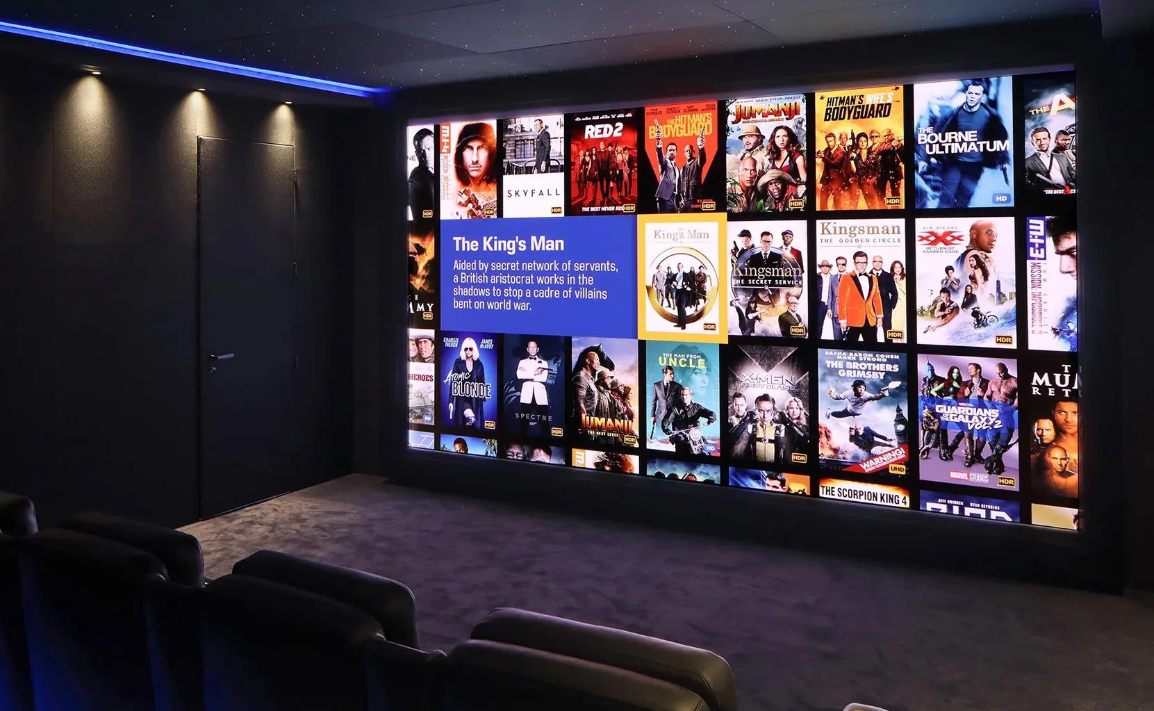 Barco residential home cinema with reclining seats and a wall display showing a film library