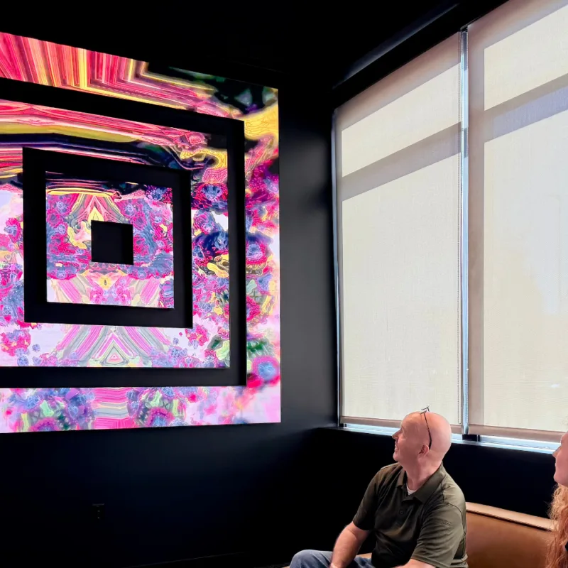 Planar Mosaic LED composition with negative space in a showroom with two seated visitors