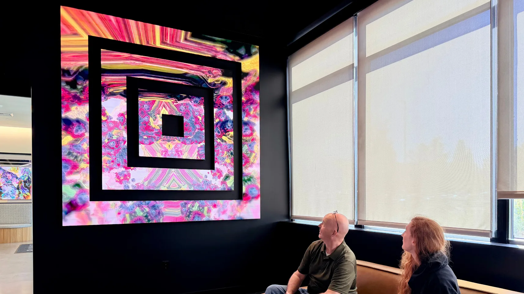 Planar Mosaic LED composition with negative space in a showroom with two seated visitors